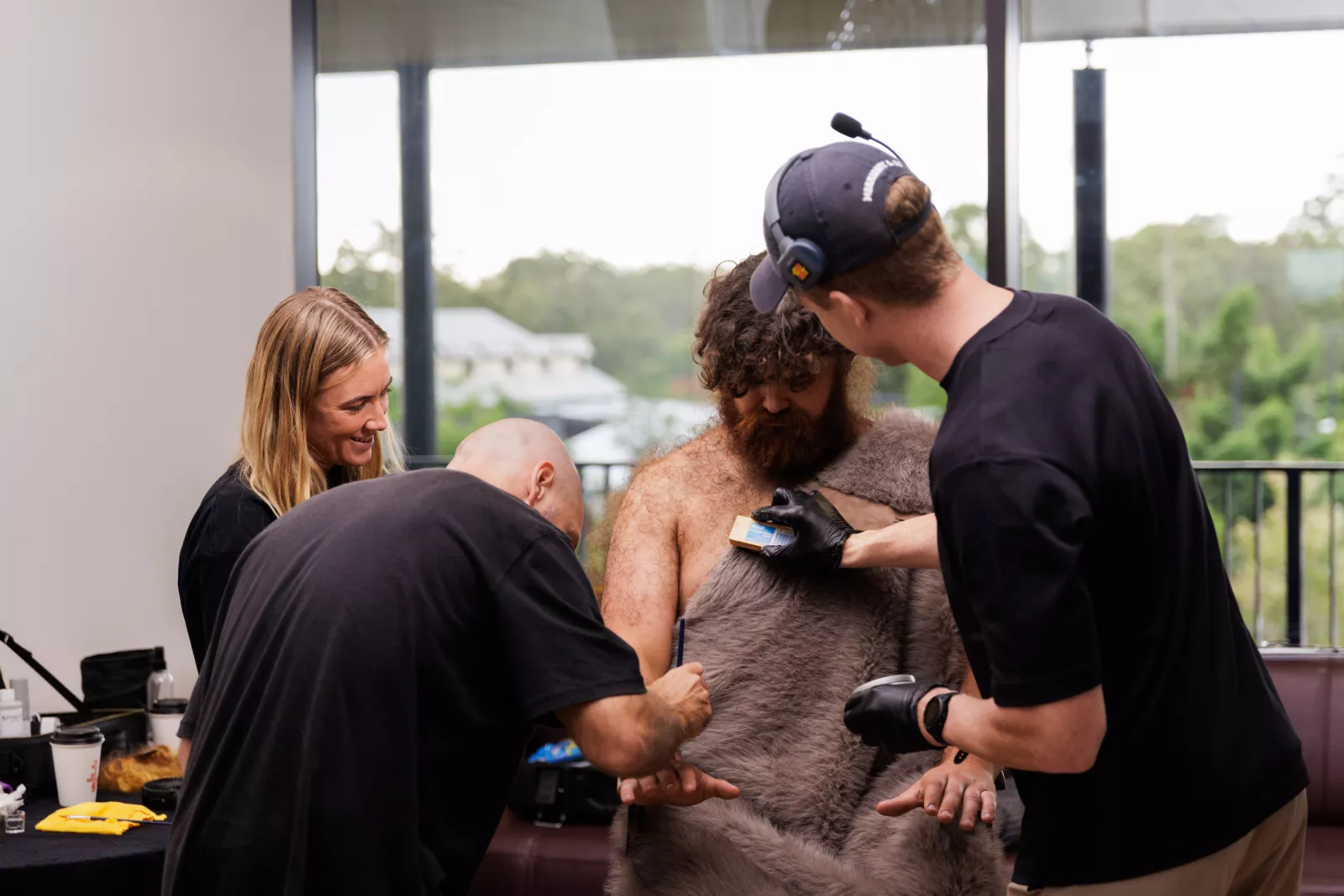 The makeup team applies hair and dirt to Newton for the Desky Commercial